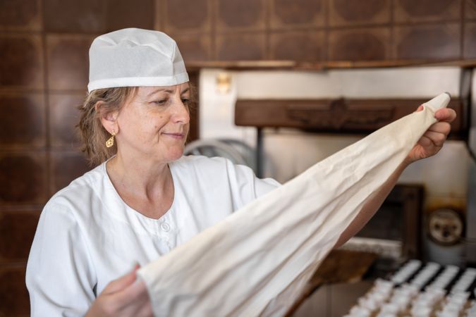 Baker woman preparing a pastry bag in order to make cupcakes