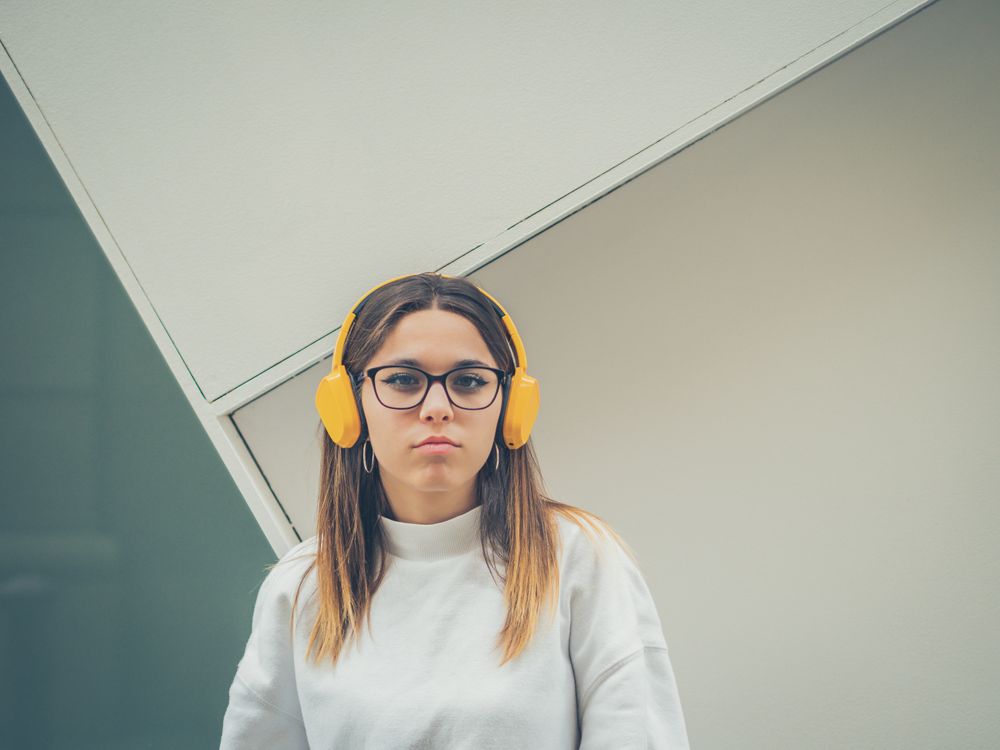 Trendy young woman with headphones and smartphone