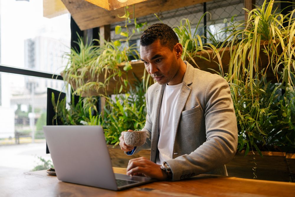 Man working on laptop at cafeteria