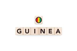 Wooden blocks bearing the name and flag of Guinea. Guinean and African Culture, national identity, travel, and geography in a copy space design.