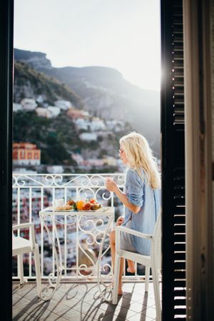 Woman eating breakfast on balcony during daytime