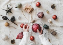 Flat-lay of holiday decoration, with hands, top view