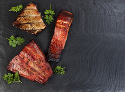 Freshly smoked salmon on dark stone