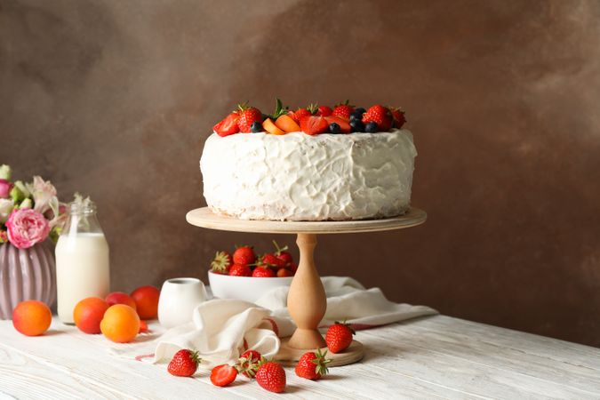 Composition with delicious berry cream cake on wooden table. Tasty dessert