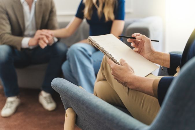 A therapist taking notes during a counseling session
