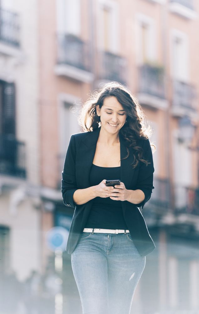 Young female walking with smartphone
