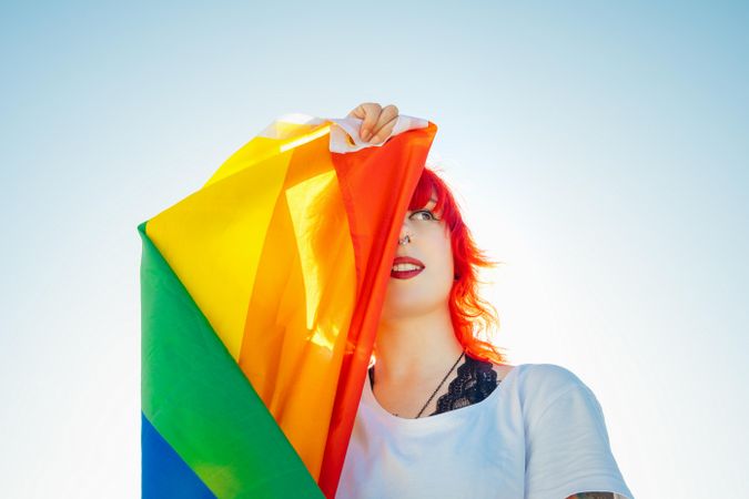 Woman with red hair holding rainbow flag
