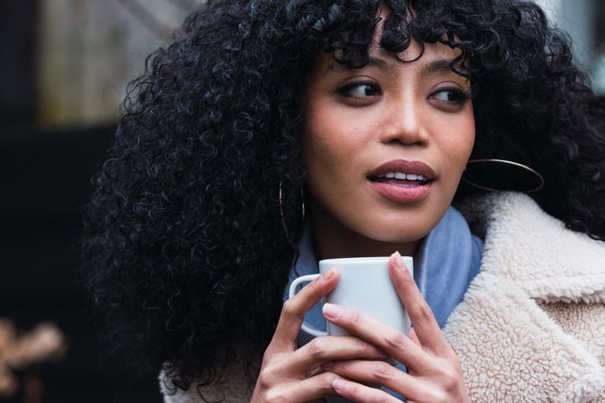 Smiling Black woman with cup of coffee