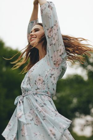 Cheerful woman twirling in her dress outdoors