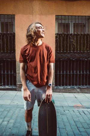 Man carrying longboard on the street