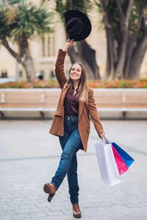 Joyful stylish woman enjoying shopping at city street