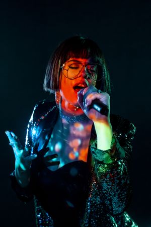 Stylish woman singing on stage
