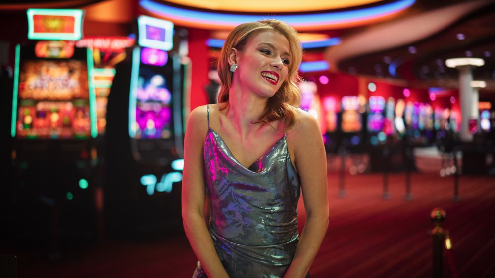 Female High Stakes Player Enjoying Glass Of Champagne, Smiling, Looking At Camera