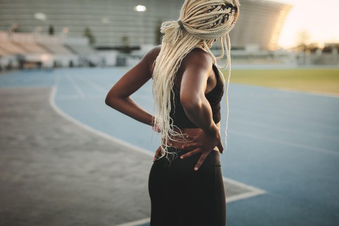 Woman athlete doing exercises in a track and field stadium