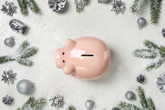 Piggy bank, fir branches and Christmas decorations on cream background, top view
