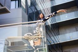 Dancer performing from crystal stairs of a modern building