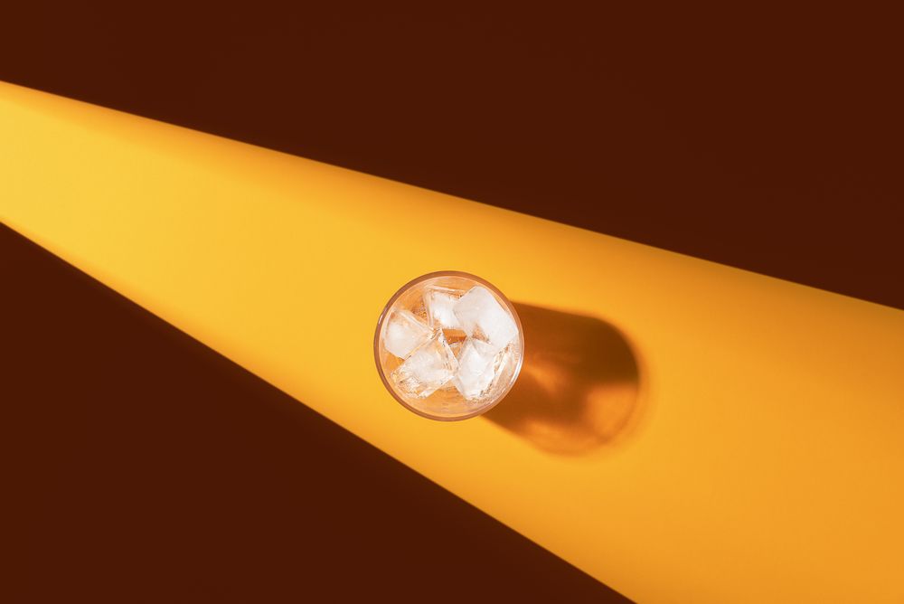 Glass with ice cubes in harsh light