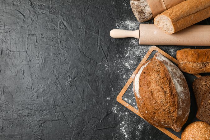 Bakery products composition on dark background, top view and space for text