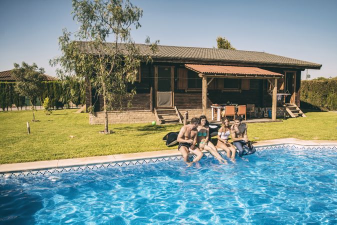 Young friends having drinks in pool