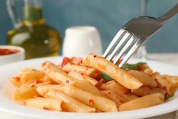 Composition with plate of tasty pasta and fork, close up