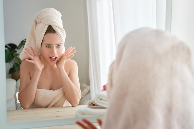 Amazed woman looking at mirror