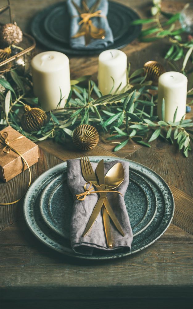 Festival holiday table setting on wooden table, with gold ornaments and branches