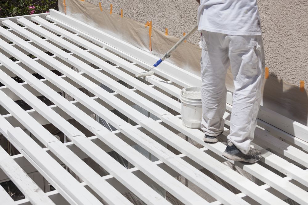 Painter Rolling Paint Onto Top of Patio Cover