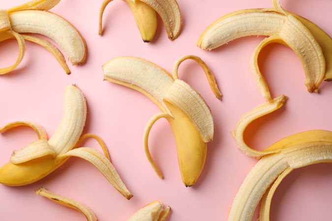 Many bananas on pink background. Fresh fruit