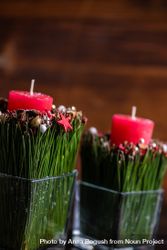 Side view of red Christmas candles with cinnamon and star anise in vase on wooden table 4BzPW4