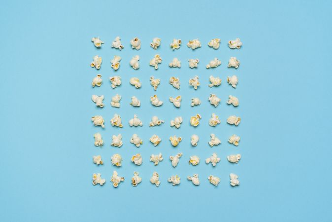 Popcorn flakes aligned symmetrically on a blue background