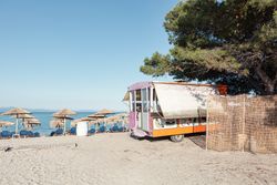 Colorful trailer and tents on sandy beach