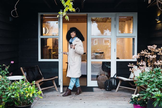 Happy Black woman standing in doorway of house