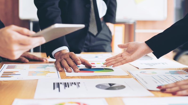 A boss and employee are discussing a chart graphDiscussing Business Reports