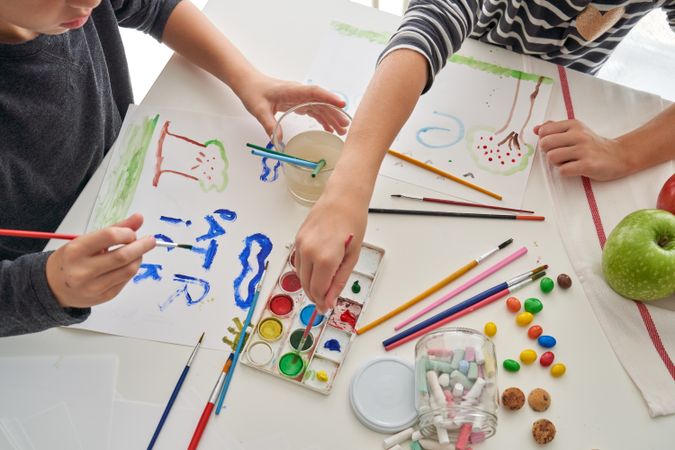 Unrecognizable children painting at table