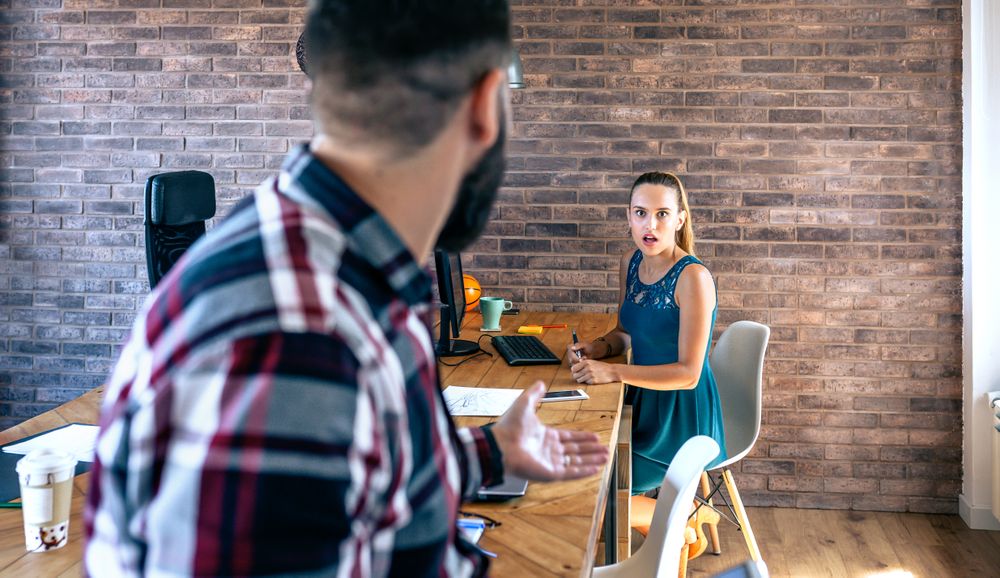 Woman shocked by what her coworker is telling
