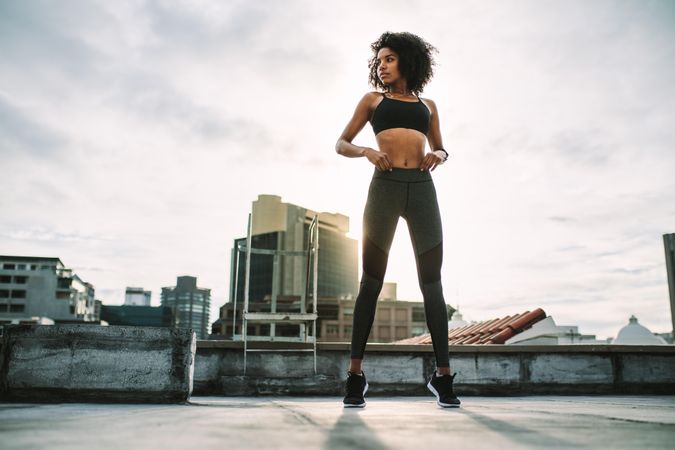 Fitness woman standing on her toes doing exercises on rooftop
