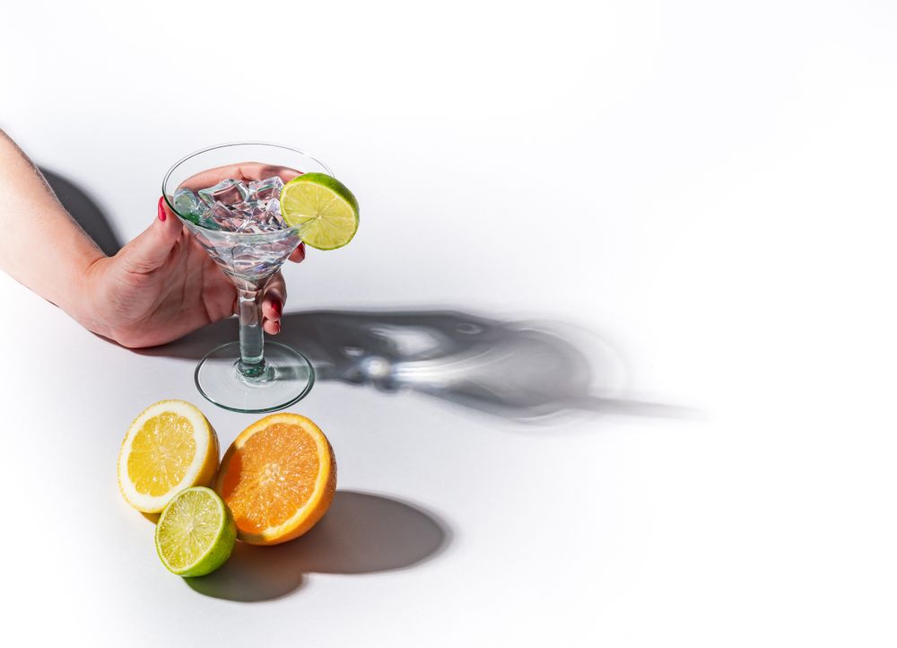 Cocktail glass with ice cubes and sliced citrus