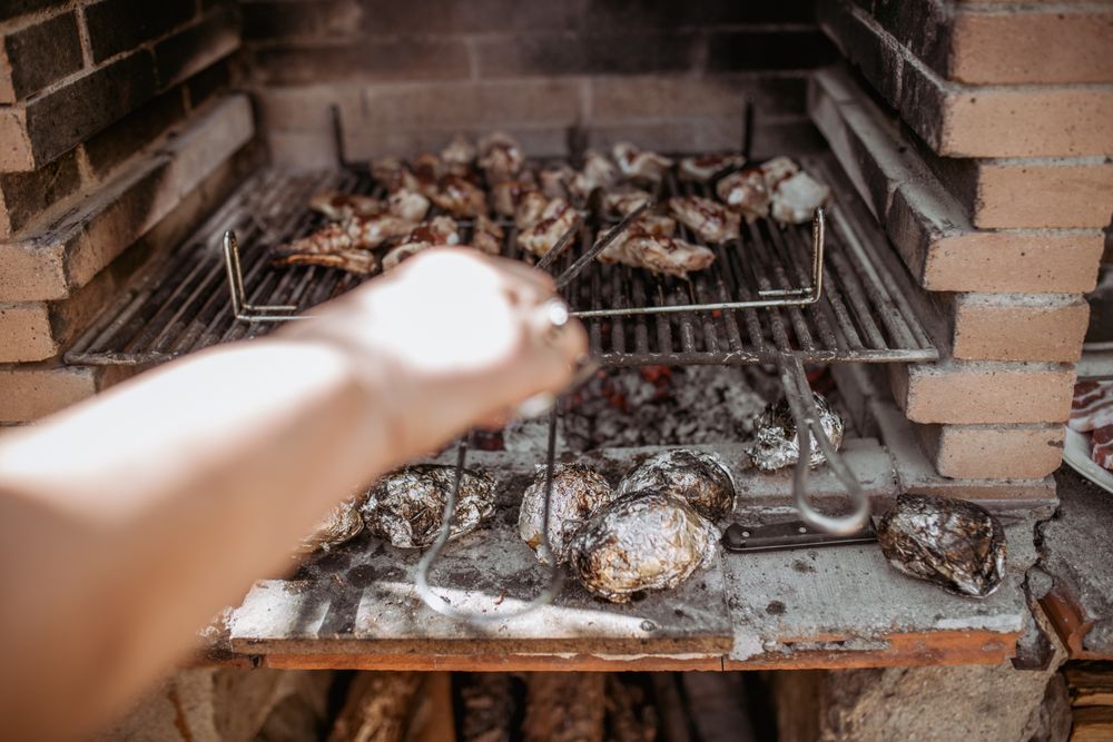 crop person cooking meat in barbecue