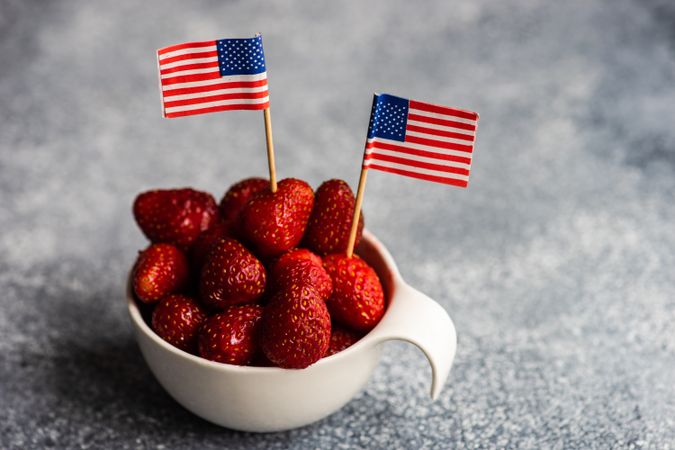 Bowl of strawberries with little USA flags with copy space