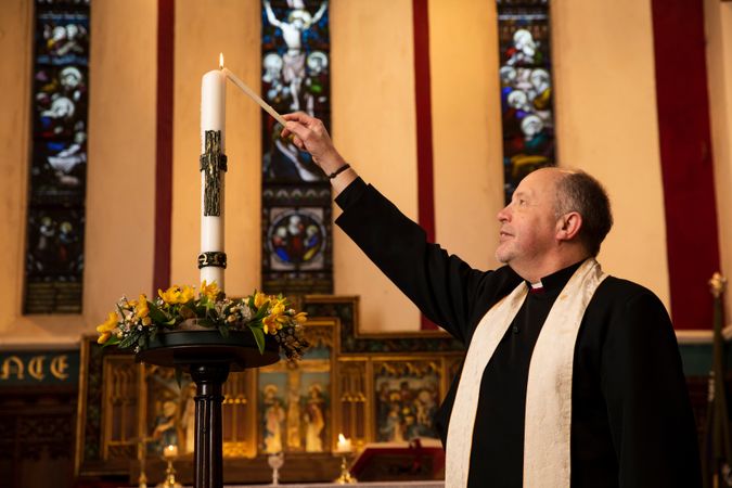 Vicar with candle in church