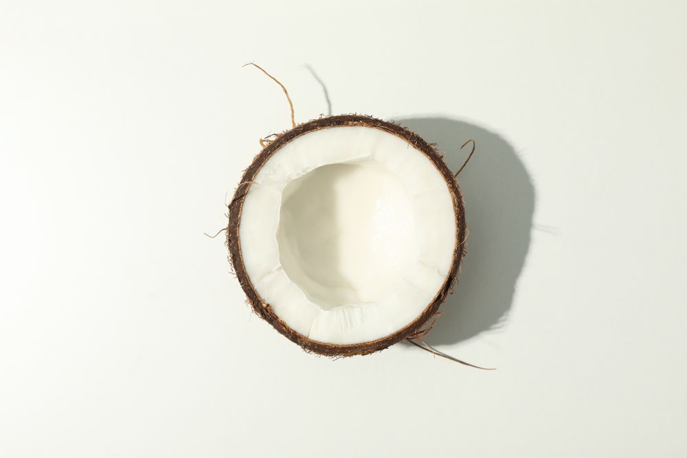 Half of coconut on plain background, top view