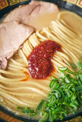 Tasty ramen with tomato salsa on noodles in broth