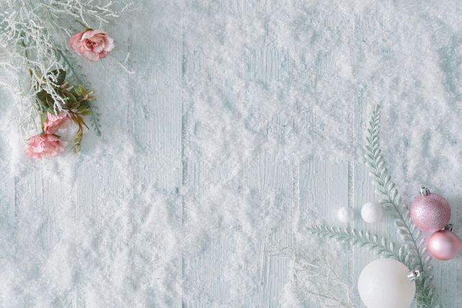 Wooden table background with snow and flowers and festive pink decorations