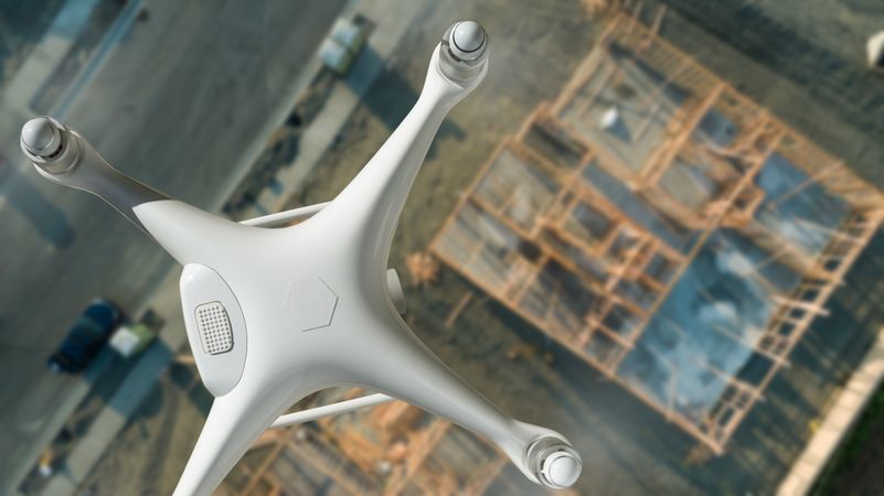 Unmanned Aircraft System Quadcopter Drone In The Air Over Construction Site