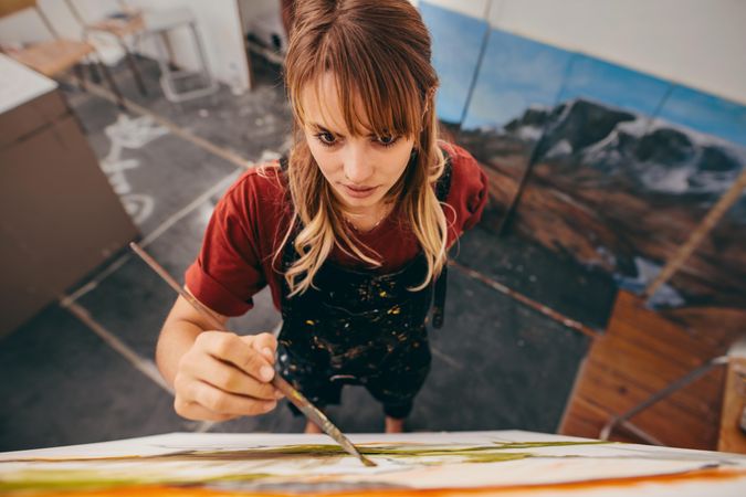 Top view of woman painter drawing on canvas