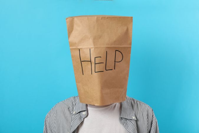 Paper bag with the word “help” on person’s head