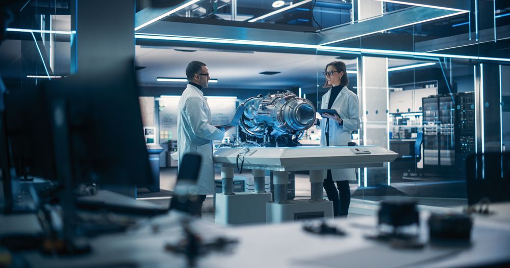 Portrait of a Female and Male Engineers Using Computers to Connect, Analyze and Discuss How to Test an Innovative Jet Engine.