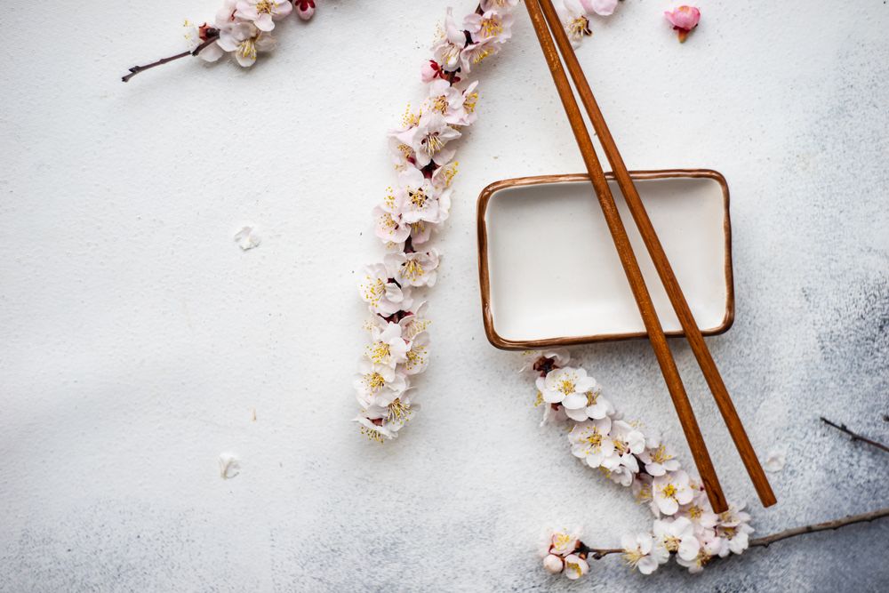 Top view of Asian style table setting with apricot blossom on trey with chop sticks