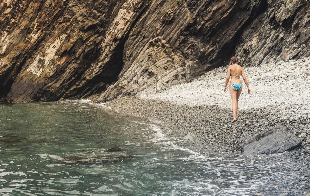 Woman walking near cliff and sea