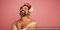 Man with decorative flower beard smiling on pink background 0Jkvn5